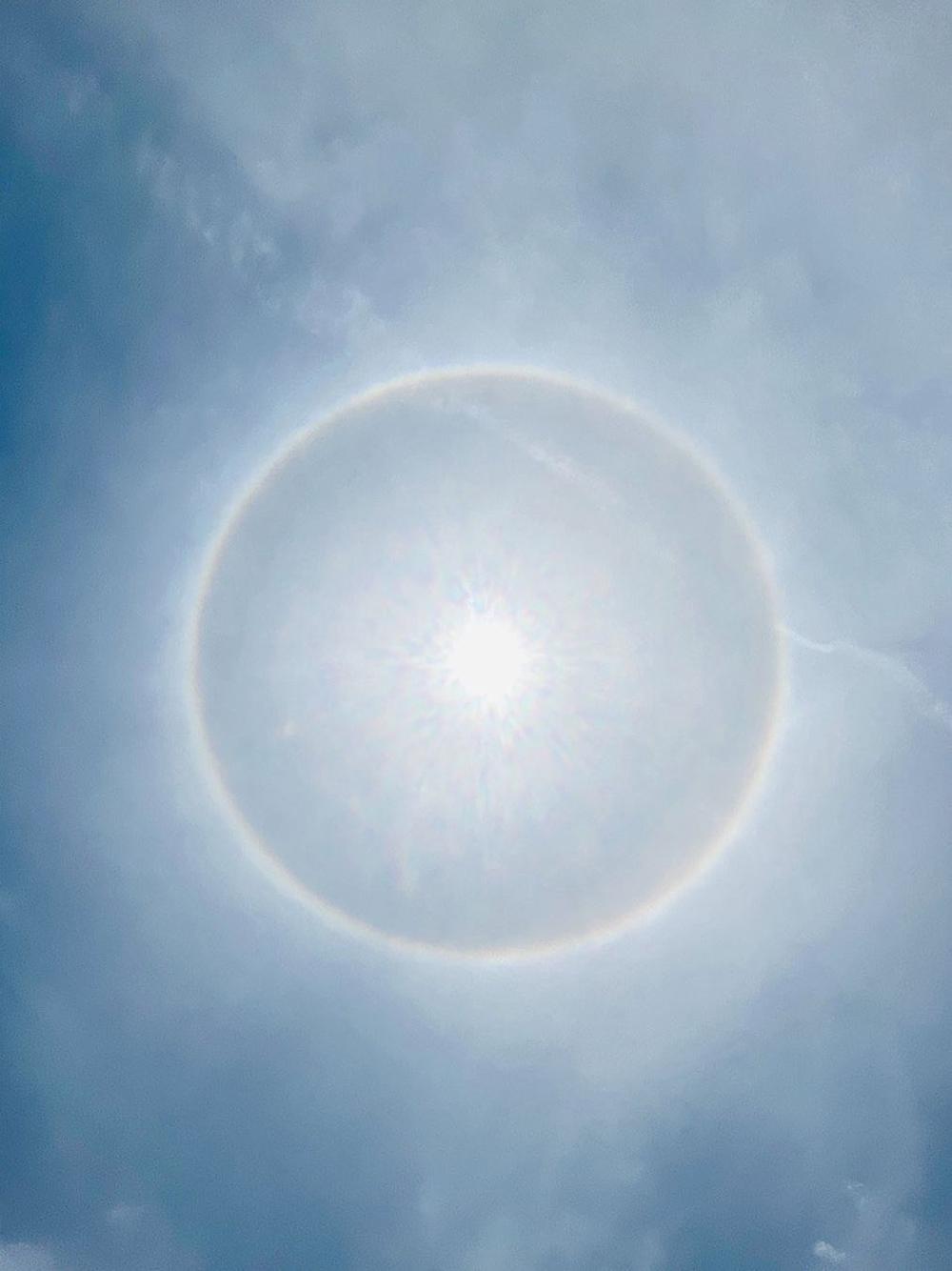  Višebojni solarni oreol snimljen mobilnim telefonom praktikanta. Svojim nebeskim okom, praktikant je video slojeve zlatnih lotosa, latica i srebrnog zmaja.