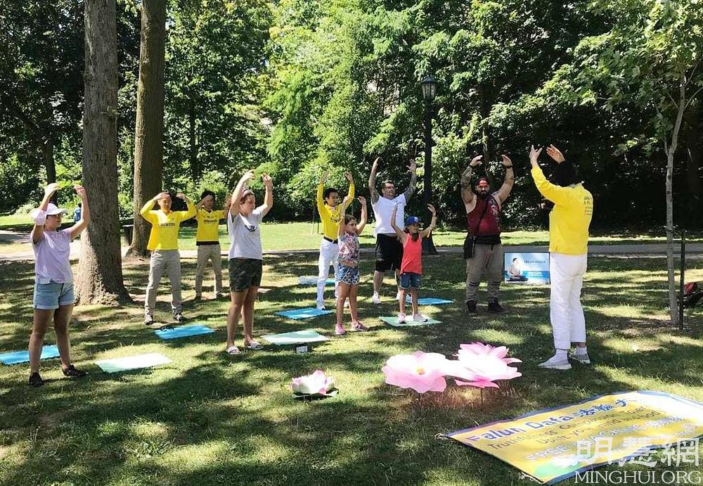 John (četvrti s desne strane u bijeloj košulji) i njegove tri kćeri uče Falun Dafa vježbe 
