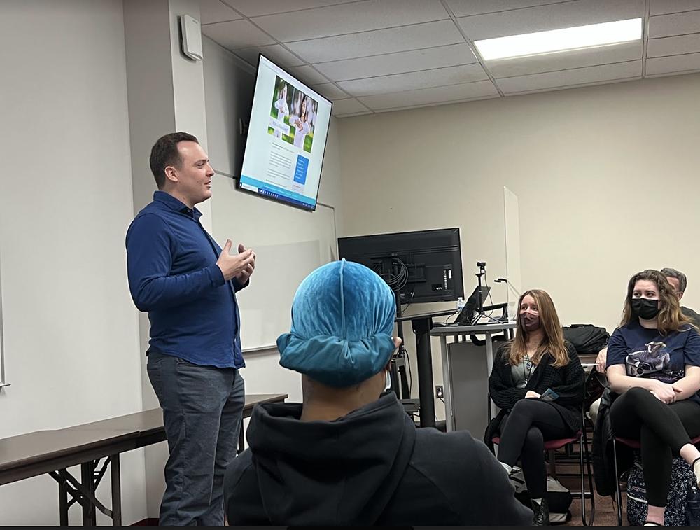 Praktikant (lijevo, stoji) govori studentima o Falun Dafa 22. februara 2022. godine.