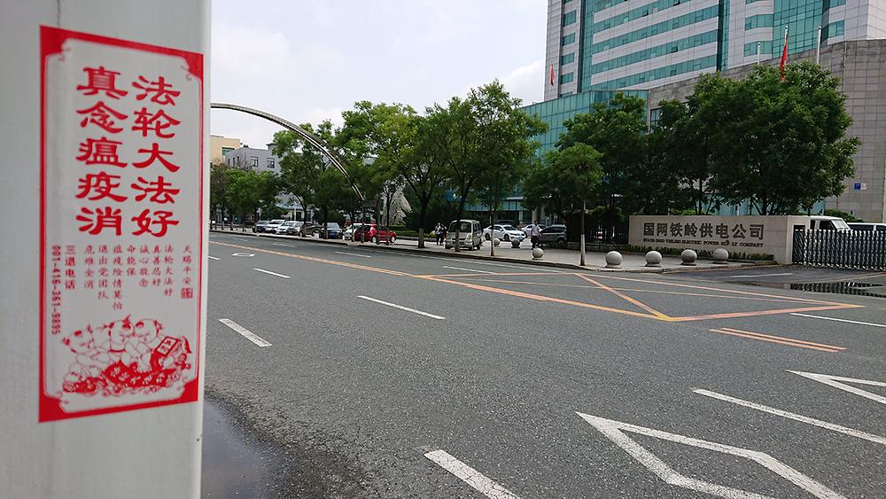 Plakat na kojem piše „Falun Dafa je veličanstven” i “ Istinitost-Dobrodušnost-Tolerancija su veličanstveni” zajedno s informacijama o istupanju iz KPK.