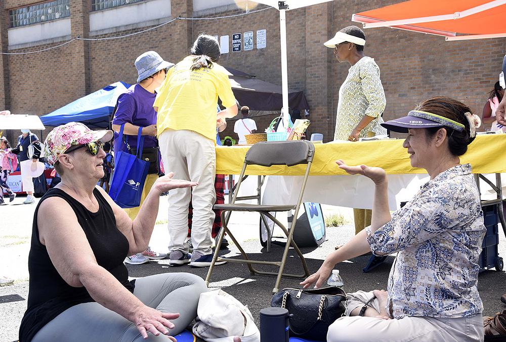 Stanovnica (lijevo) uči petu Falun Dafa vježbu. 