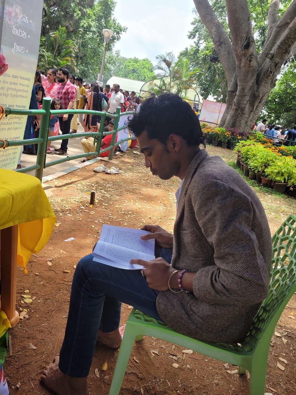 Amul Vaishu čita Falun Dafa knjigu na štandu.