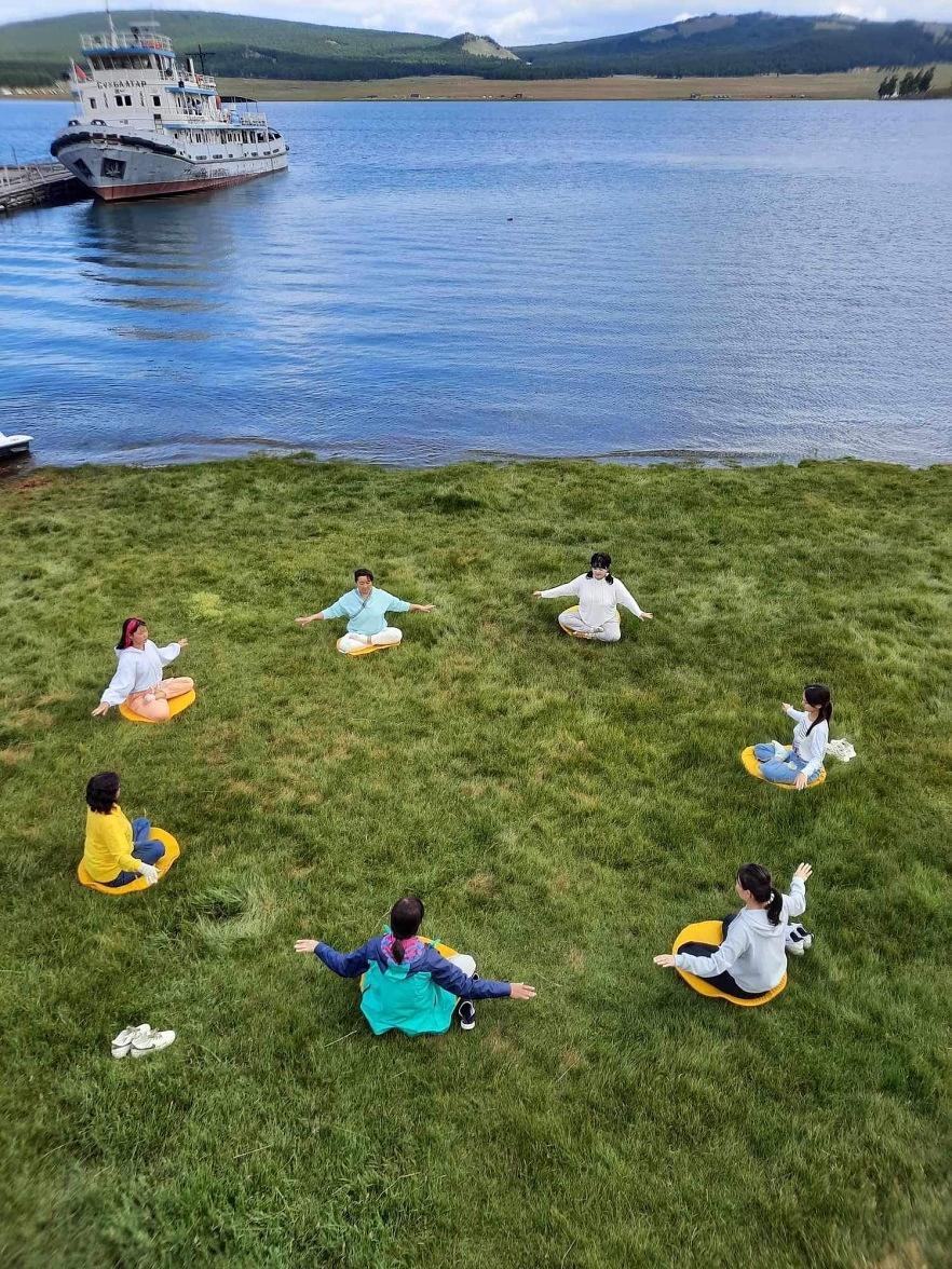 Praktikanti su pored jezera demonstrirali Falun Dafa sjedeću meditaciju. 