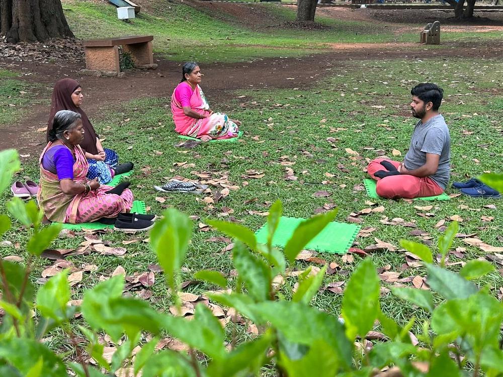 Jose Adapoor (desno), praktikant, pokazuje trima ženama kako da rade petu vježbu.